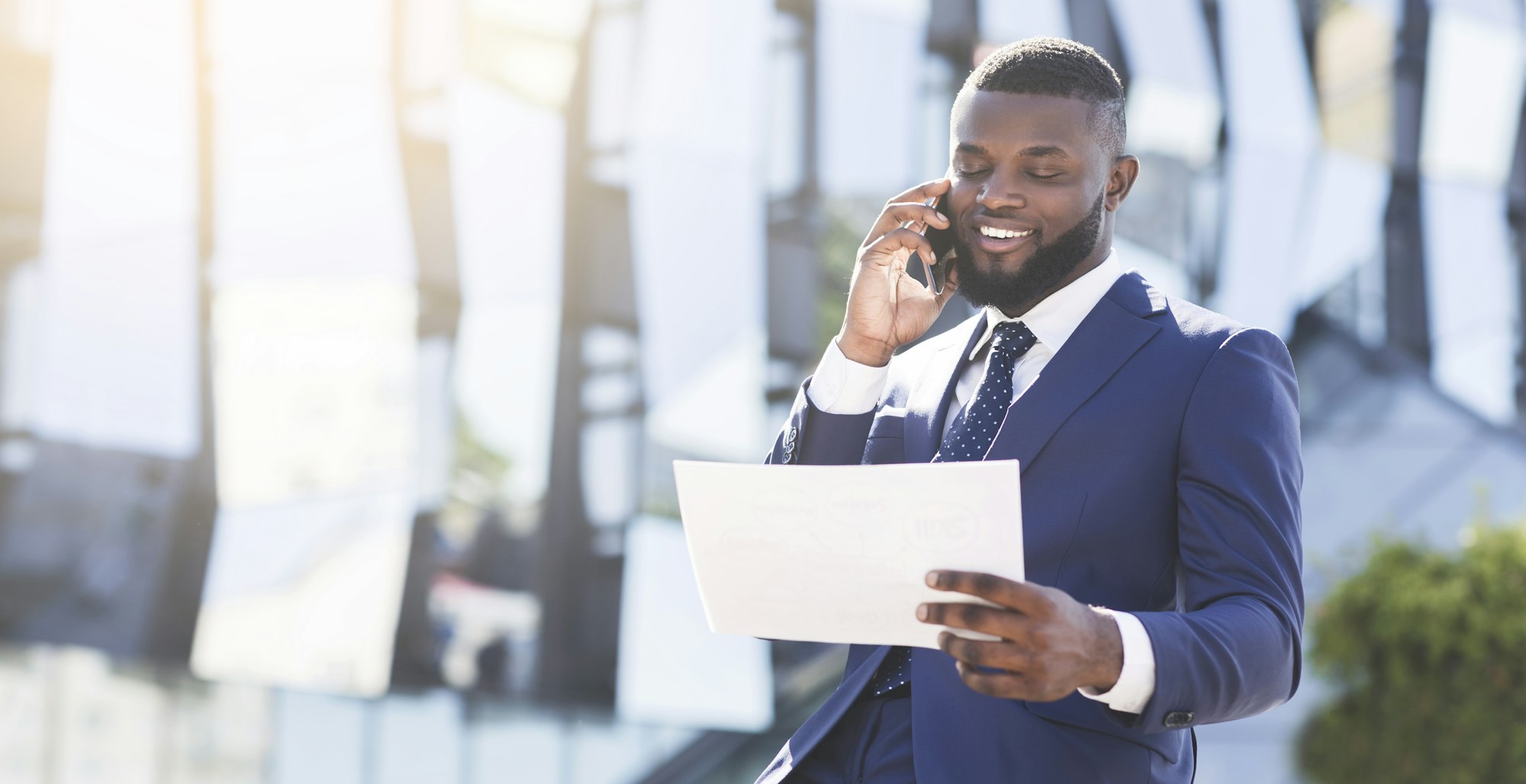 Businessman Negotiating Business Deal By Phone Sitting In Urban Area