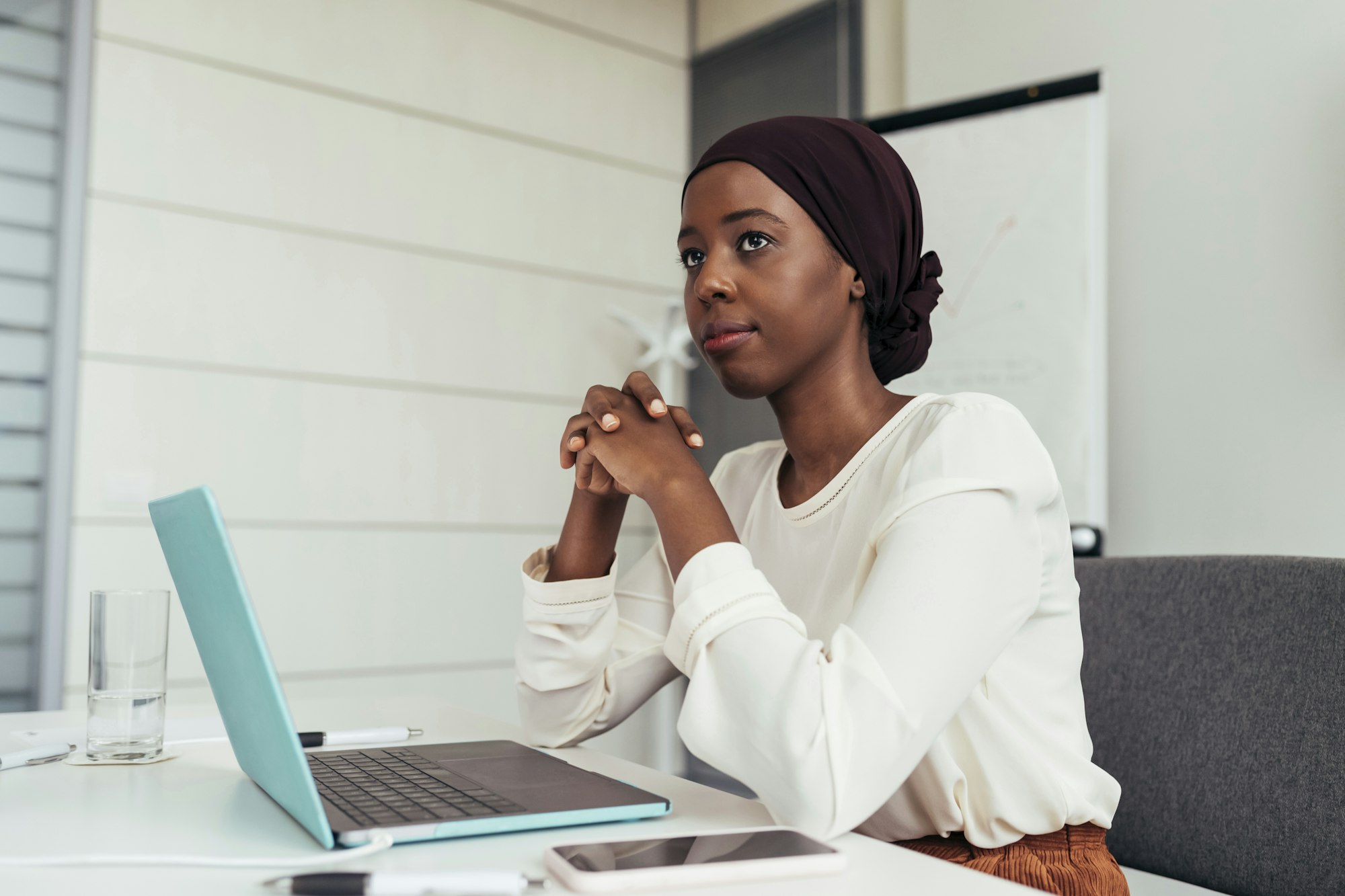 Professional woman deep in thought at her office desk.