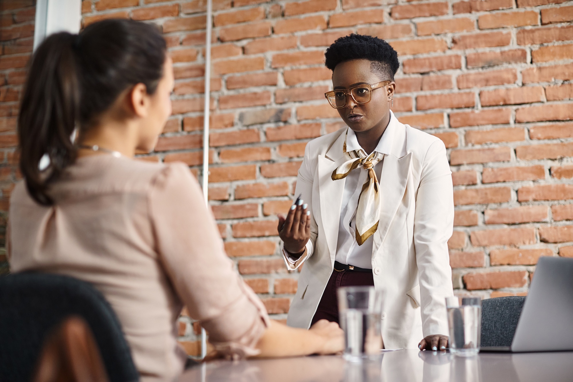 Black female executive talking to female colleague during a meeting in the office.