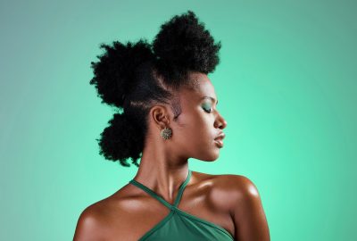 Black woman, makeup and face on skin for beauty, fashion and cosmetics against green backdrop. Mode